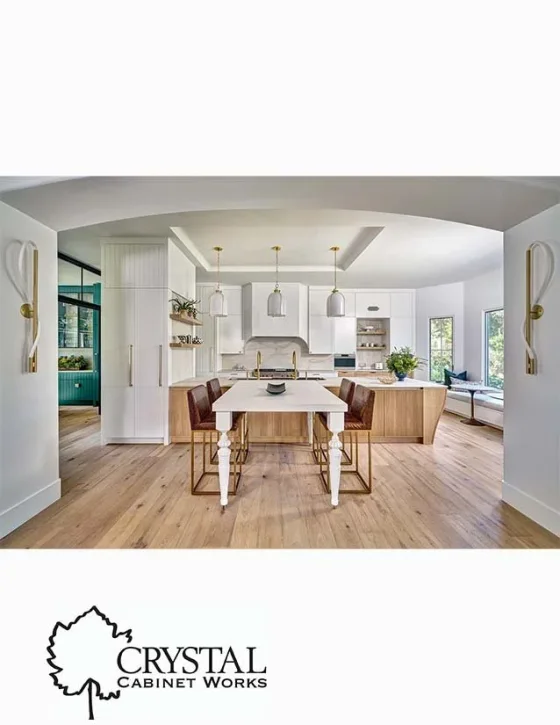 Modern open-concept kitchen with white cabinets, wooden island, pendant lighting, and large windows.