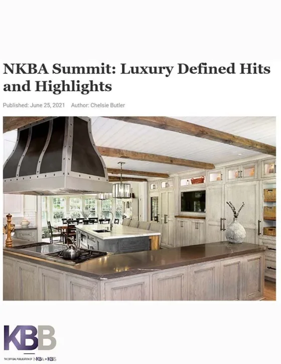 Interior of a rustic kitchen with white cabinets, wooden beams, and a large kitchen island.
