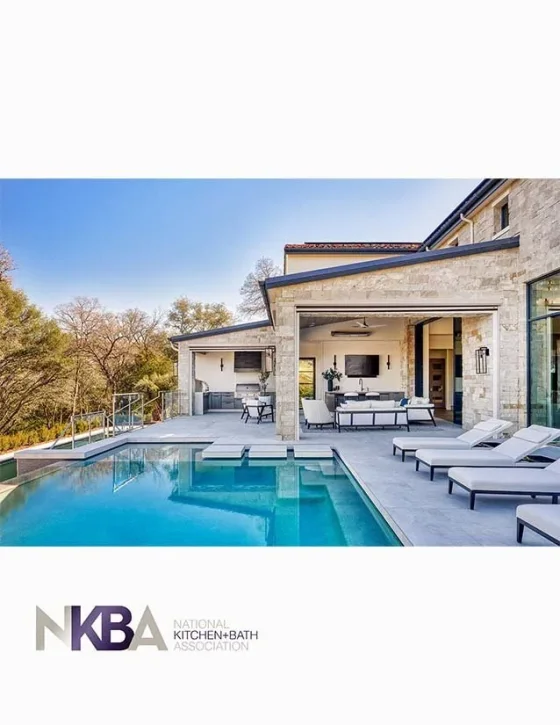 Exterior view of a modern house with a swimming pool, outdoor lounge area, and patio furniture in a backyard with trees and blue sky.